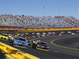 NASCAR settles charter lawsuit with Michael Jordan-backed 23XI Racing and Front Row Motorsports Nascar race taking place with cars on the bend in the track