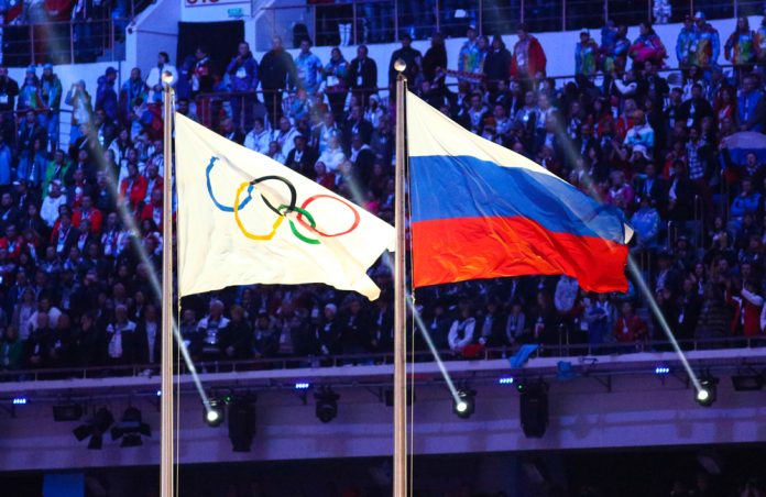 A Russian flag alongside the Olympic flag