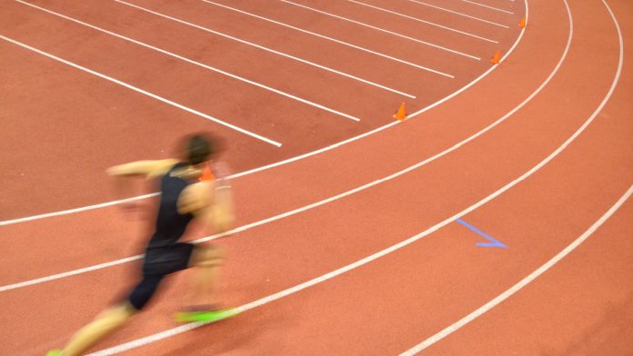 Man running round track.