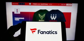 Fanatics strengthens sports betting venture with PointsBet US acquisition Person holding a phone with the Fanatics logo in front of the company's website.