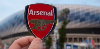 Arsenal extends Camden Town Brewery deal into 2023/24 season Man holding an Arsenal badge.