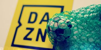 DAZN signs exclusive National League rights in domestic English football debut A yellow DAZN sign next to a football in a green net.