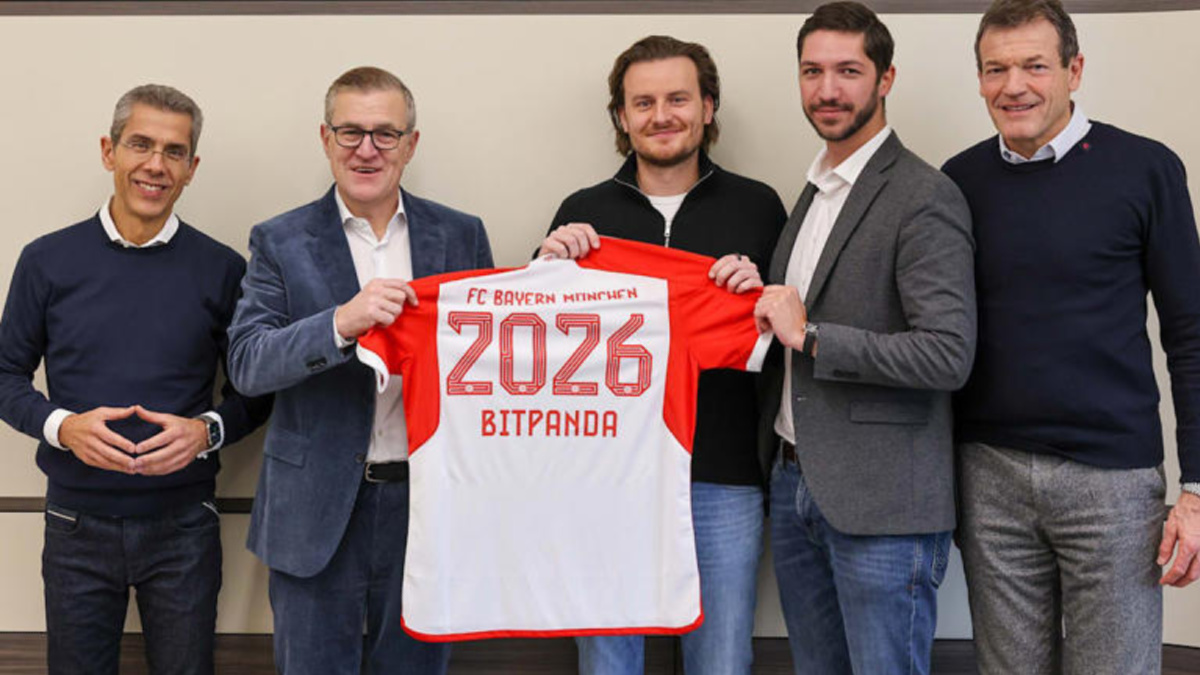 Bayern Munich and Bitpanda employees holding up football shirt