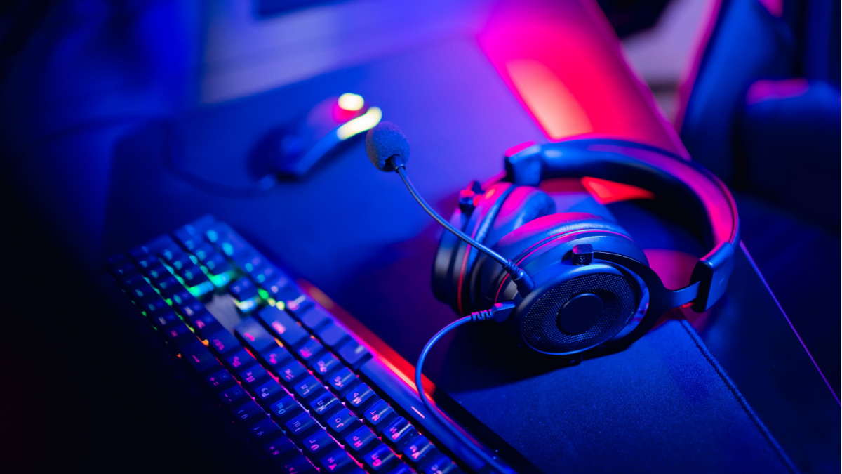 Gaming keyboard and headset on a desk.