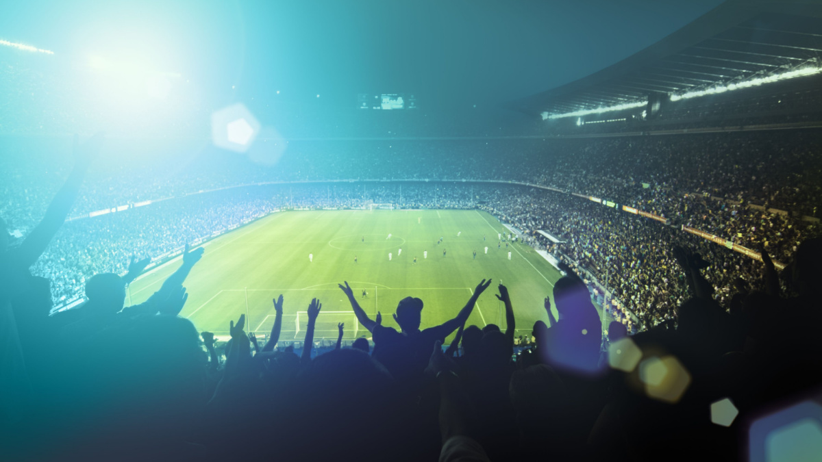 Football fans watching a game in a stadium.