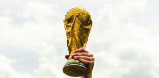 FIFA elevates fan experience with Visa partnership extension A hand lifting the World Cup trophy.