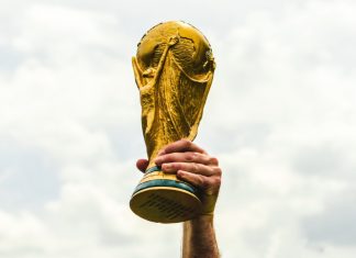 FIFA elevates fan experience with Visa partnership extension A hand lifting the World Cup trophy.
