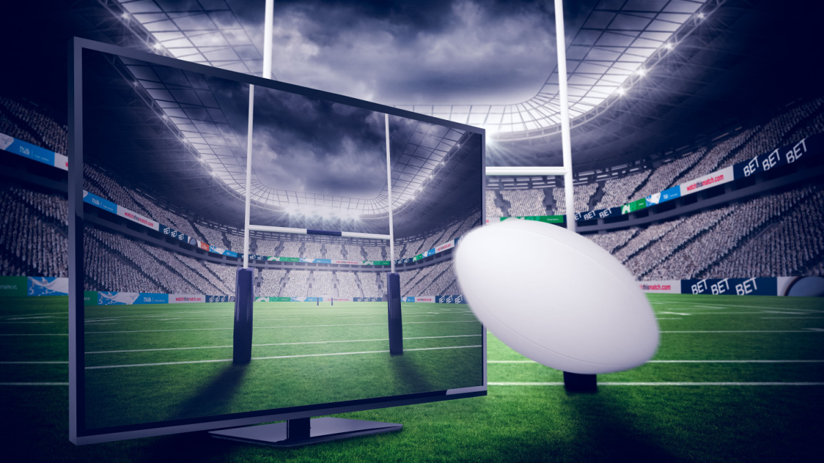 Rugby ball positioned in front of TV and rugby sticks.