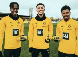 Borussia Dortmund scores with PRIME Hydration partnership Three BVB players posing with yellow PRIME drinks on a football pitch.