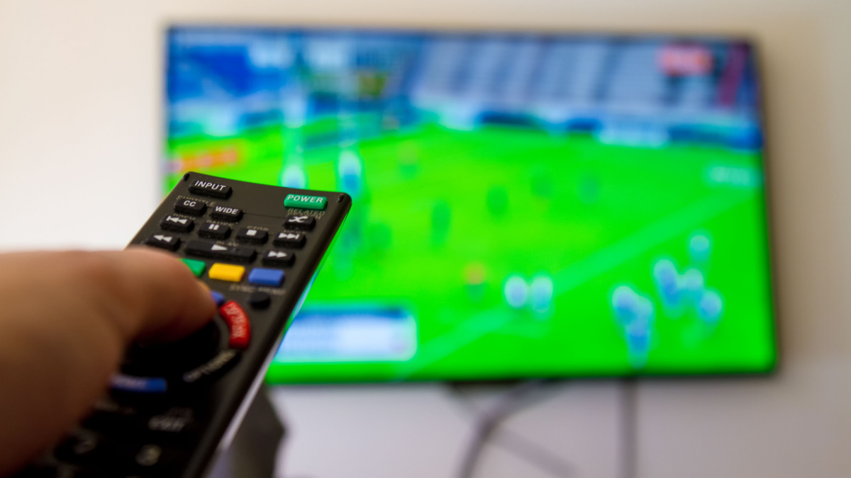 Close up shot of man watching a rugby game.