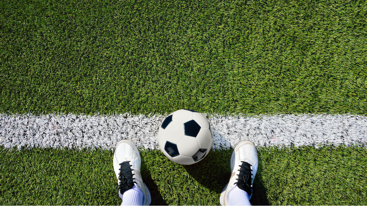 A football at a player's feet from the player's perspective.