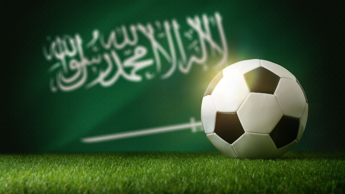 A football sat in front of the Saudi Arabian national flag