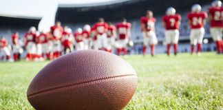 Jon Steinbrecher, MAC: upholding integrity amidst collegiate sports betting boom Close up of an American football on the field, players in the background.