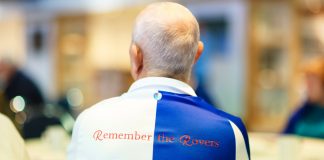 Blackburn Rovers receives grant to fuel Alzheimer’s support Man satdown with 'Remember The Rovers' written on the back of his football kit.