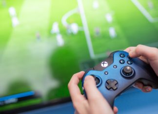 EFL inks deal with EA SPORTS FC to bolster global appeal Man playing video game using an XBOX controller.