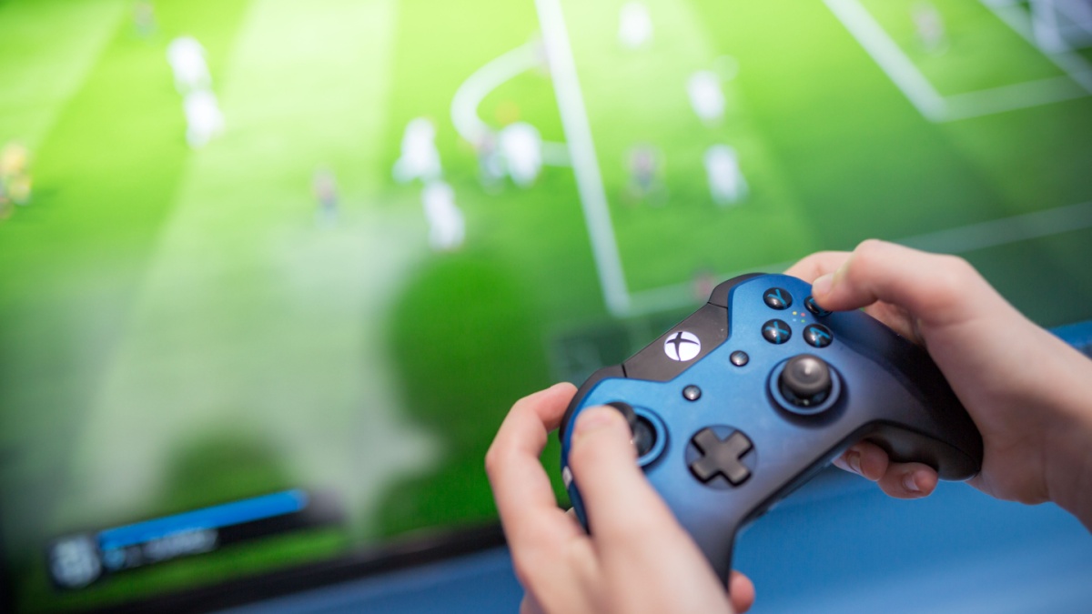 Man playing video game using an XBOX controller.