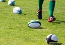 English Premiership Rugby extends flagship title sponsorship Rugby. Balls lying on pitch during workout. Closeup of legs running rugby player.