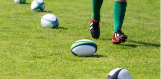 TNT Sports bolsters rugby portfolio with Autumn Nations Rugby. Balls lying on pitch during workout. Closeup of legs running rugby player.