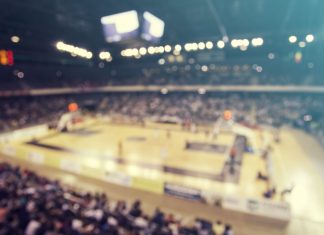 Caitlin Clark sparks record growth in WNBA sales Defocused background of crowd of people in a basketball court