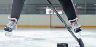 PokerStars moves to up US visibility with Philadelphia Flyers deal Legs of male hockey player in sports uniform and skates moving down rink in front of camera against stadium environment while going to shoot puck.