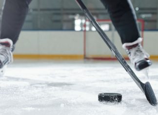 PokerStars moves to up US visibility with Philadelphia Flyers deal Legs of male hockey player in sports uniform and skates moving down rink in front of camera against stadium environment while going to shoot puck.