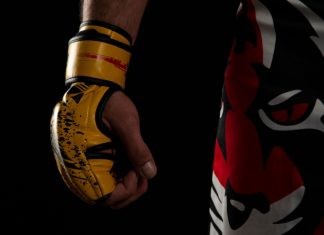 OKTAGON MMA ‘exemplifies’ UK growth via deal with SkyBet Mixed martial arts (MMA) fighter. Detail of the yellow glove with tiger pants on black background.