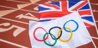 Microplus named title sponsor of UK Athletics Olympic trials An Olympic and British union jack flag flutter together above the starting line of a red athletics track.