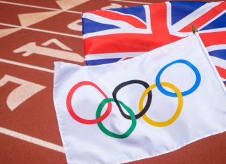 Microplus named title sponsor of UK Athletics Olympic trials An Olympic and British union jack flag flutter together above the starting line of a red athletics track.