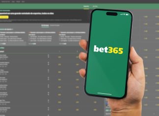 bet365 suffers ‘biggest payout’ of the season on the final day Man holding a smartphone iPhone 14 Pro with Bet365 betting provider app on the screen.