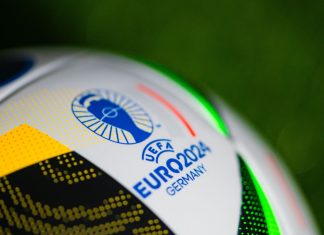 Ladbrokes joins the Euro 2024 marketing wave with latest campaign Logo of Euro 2024 in Germany. Detail at Official Adidas soccer ball Fussballliebe for Euro 2024 placed on green grass.