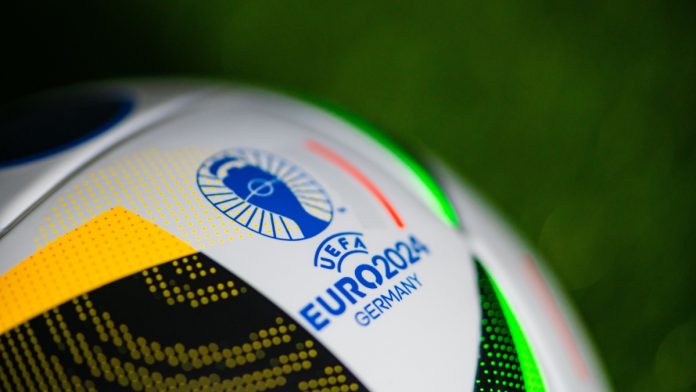 Logo of Euro 2024 in Germany. Detail at Official Adidas soccer ball Fussballliebe for Euro 2024 placed on green grass.