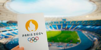 Kuaishou set to boost Chinese engagement for Paris Olympics Icon of Summer olympic Games Paris 2024 Held by Athlete. Modern Stadium in background. Wallpaper for Summer Olympic Game in Paris 2024.