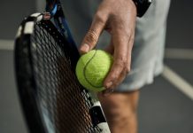Six and counting: Folliot banned in tennis fixing scandal Close-up of male hand holding tennis ball and racket. Professional tennis player starting set.