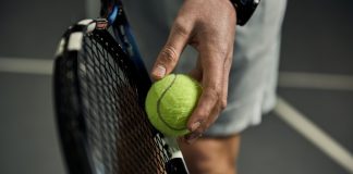 Six and counting: Folliot banned in tennis fixing scandal Close-up of male hand holding tennis ball and racket. Professional tennis player starting set.