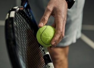Six and counting: Folliot banned in tennis fixing scandal Close-up of male hand holding tennis ball and racket. Professional tennis player starting set.