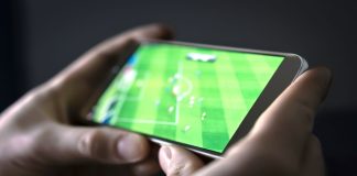 FA charges Torquay United defender for betting offences Watching football and sport stream with mobile phone.