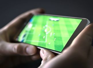 FA charges Torquay United defender for betting offences Watching football and sport stream with mobile phone.