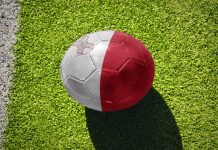 Malta FA Trophy gains Meridianbet as title sponsor Football ball with the national flag of Malta on the green field near the white line.