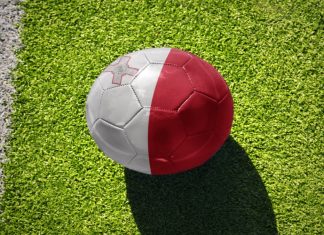 Malta FA Trophy gains Meridianbet as title sponsor Football ball with the national flag of Malta on the green field near the white line.