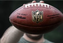 Can the NFL turn Super Bowl success into global growth? A professional athlete holds a ball for NFL ball.