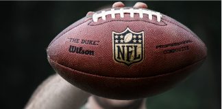 NFL Christmas games draw 65 million viewers on Netflix A professional athlete holds a ball for NFL ball.