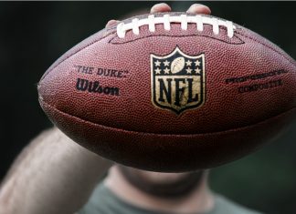 Can the NFL turn Super Bowl success into global growth? A professional athlete holds a ball for NFL ball.