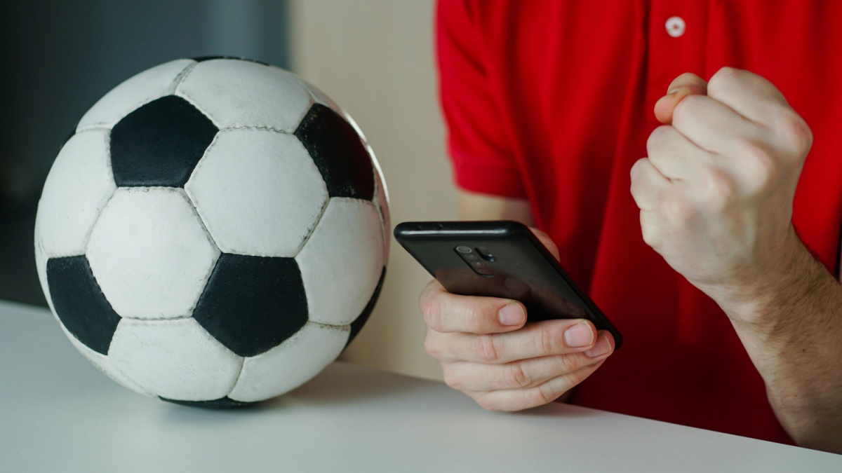 Man celebrates football win on his phone