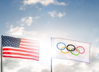 Orlando eyes up Florida Olympics amid US sporting boom The iconic Olympic flag waves proudly beside the American flag under a vibrant sky.