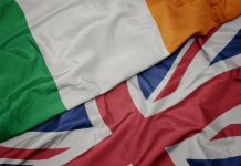 Rugby authorities deny British-Ireland merger waving colorful flag of great britain and national flag of ireland.