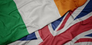 Rugby authorities deny British-Ireland merger waving colorful flag of great britain and national flag of ireland.