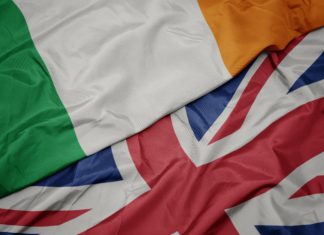 Rugby authorities deny British-Ireland merger waving colorful flag of great britain and national flag of ireland.