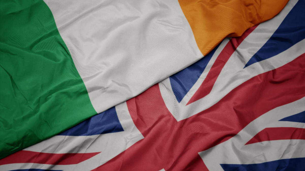 waving colorful flag of great britain and national flag of ireland.