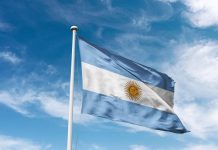 Argentine football club “lack respect” by fielding influencer Argentina flag waving at cloudy sky background. the Argentine Republic flag.