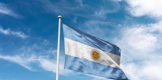 Argentine football club “lack respect” by fielding influencer Argentina flag waving at cloudy sky background. the Argentine Republic flag.